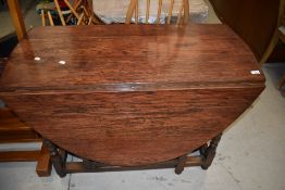 A traditional oak dining table having turned gate legs
