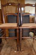 A pair of Edwardian mahogany bedroom chairs having canework seats and turned legs