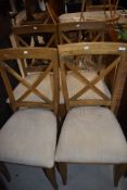 A set of four modern dining chairs having upholstered seats