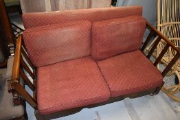 A vintage stained frame drop end settee, on shepherds castors