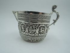 A Victorian silver cream jug having zodiac panel decoration, plain cartouche and cast dog mask