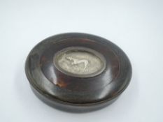 An oval tortoise shell box having an inset moulded white metal plaque to lid depicting a gun dog