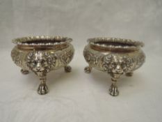 A pair of Edwardian silver salts by Garrard having gadrooned rims, trefoil lion mask and ball and
