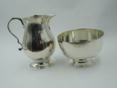 A silver cream jug and sugar bowl of plain form bearing oversized hallmarks, London 1974, Payne &