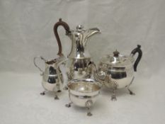 An Edwardian Irish silver four piece tea set of plain circular form having wooden scroll handles,