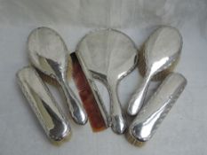 A silver six piece dressing table set of plain form having decorative edges and bearing monogram