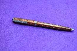 An R Esterbrook ballpoint pen in orange.