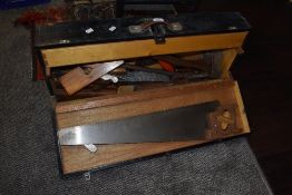 A woodworkers tool chest containing hand tools and wooden planes