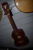 A modern large ukulele, believed to be Baritone type, motif to headstock , and hard case