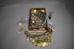 A tin containing a selection of metal costume jewellery