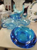 A collection of art glass bowls and vases in blue hues.