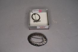 An HM silver oval brooch of celtic knot form and a white metal and marcasite brooch stamped silver