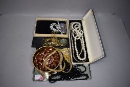 A selection of costume jewellery including gold plated chains, diamante, two strings of mourning