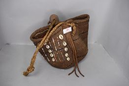 An ethnic hand woven bag having shells and bead decoration