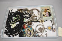 A selection of costume jewellery including beads, brooches, rosary beads, watches etc
