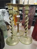 Three large brass candle stick holders.