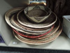 A collection of round, shallow baskets.
