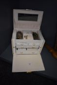A cream travel jewellery chest containing a selection of costume jewellery