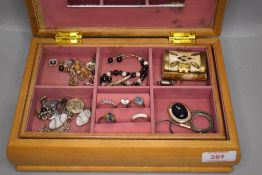 A wooden jewellery box containing a selection of costume and silver jewellery including rings etc