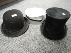 A vintage bowler hat, a top hat and a sailors cap.