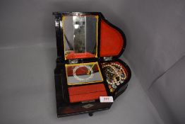 A Piano shaped jewellery box with oriental decoration includes costume jewellery