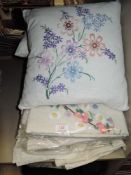 A collection of vintage table linen including extensively embroidered items and cushions beautifully