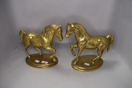 A pair of brass horse mantle figures