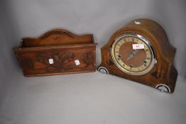An arts and craft style hand made and carved newspaper box and a mantle clock