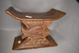 A traditional African tribal head rest carved from ethnic wood with double fish design