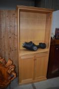 A modern beech finish full height bookcase having adjustable top shelves and cupboard under, w 84cm