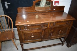 An early 20th Century oak sideboard having small mirror ledge back, on twist frame
