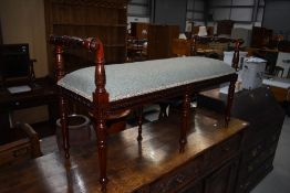 A reproduction period style duet stool having foliate decoration and overstuffed green upholstered