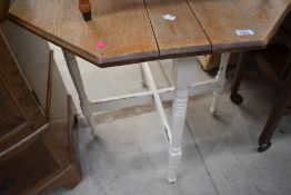 A fold out hexagonal oak topped tea table
