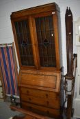 A 1920's full height oak bureau having leaded glass top over drawer base, w 82cm