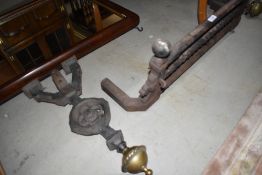 A vintage cast iron fire front/fire dogs having brass finials