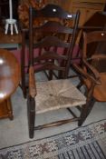 A period oak rush seated ladder back carver chair
