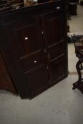 An early 19th Century oak panelled corner cupoard
