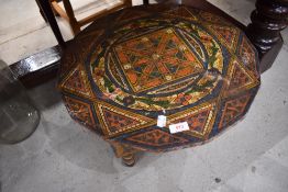 A small Eastern style painted low table, having canted edge, diameter approx. 50cm