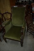 A William IV mahogany gents armchair having sctroll arm, fluted legs and brass castors, with green