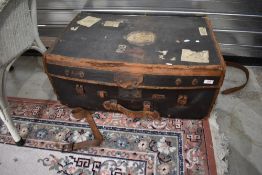 A vintage part leather travel luggage trunk , bearing various vintage labels including British