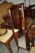 A reproduction mahogany effect cheval mirror