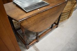 A traditional oak gateleg dining table having turned legs