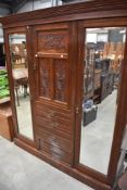 A Victorian mahogany mirror door wardrobe, triple section with centre press and drawer section,