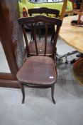 A pair of traditional bentwood chairs having ply seats, one with foliate detail