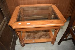 A modern stained frame coffee table having glazed top and bergere canework undertier, approx 68 x