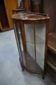 A mid 20th Century walnut demi lune display cabinet