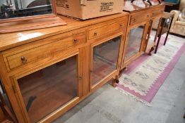 A pair of inlaid shop style cabinets, having frieze drawers and glass shelves
