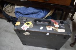 A vintage small suitcase, with travel labels, etc