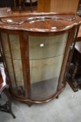 A vintage walnut bow fronted display cabinet, damage to one pane