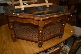 A modern stained frame octagonal coffee table having glass top and canework undertier